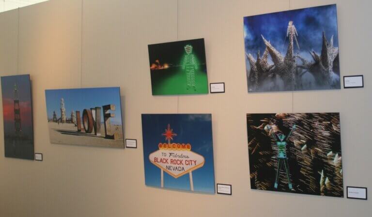 Exhibition wall from 2014 Burning Man exhibition. Includes photographs.