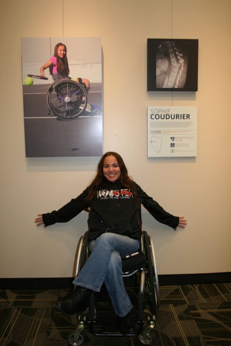 The Power of a High Five Exhibition participant posing next to artwork.