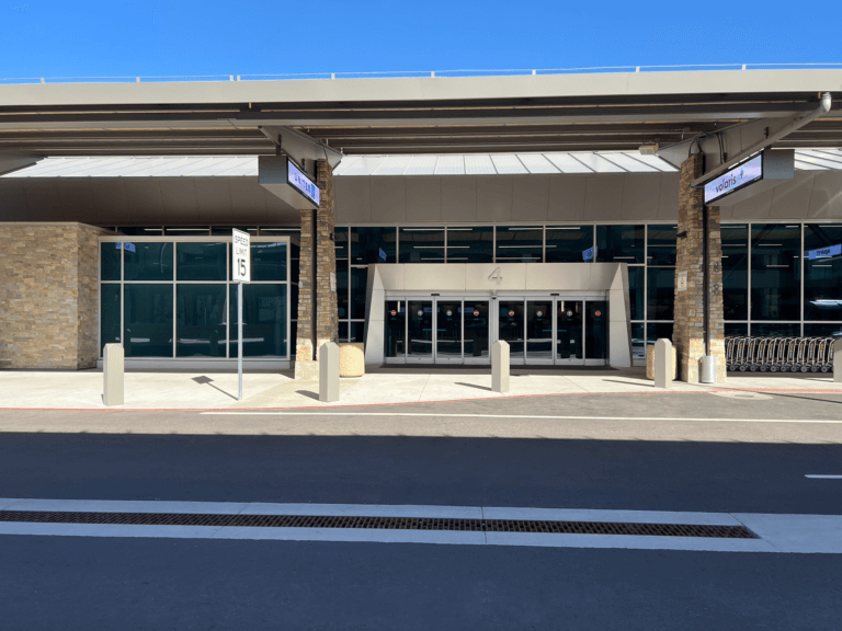 Landscape view of Ticketing Hall door 4 with road and safety bollards.