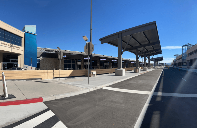 Landscape view of loop road featuring a shade structure and Ticketing Hall entrance.