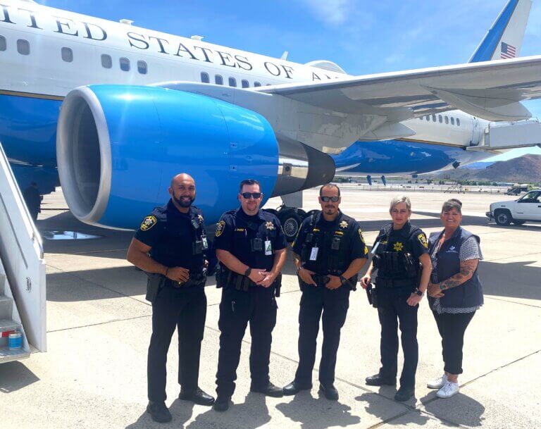 Police officers posing in front of aircraft