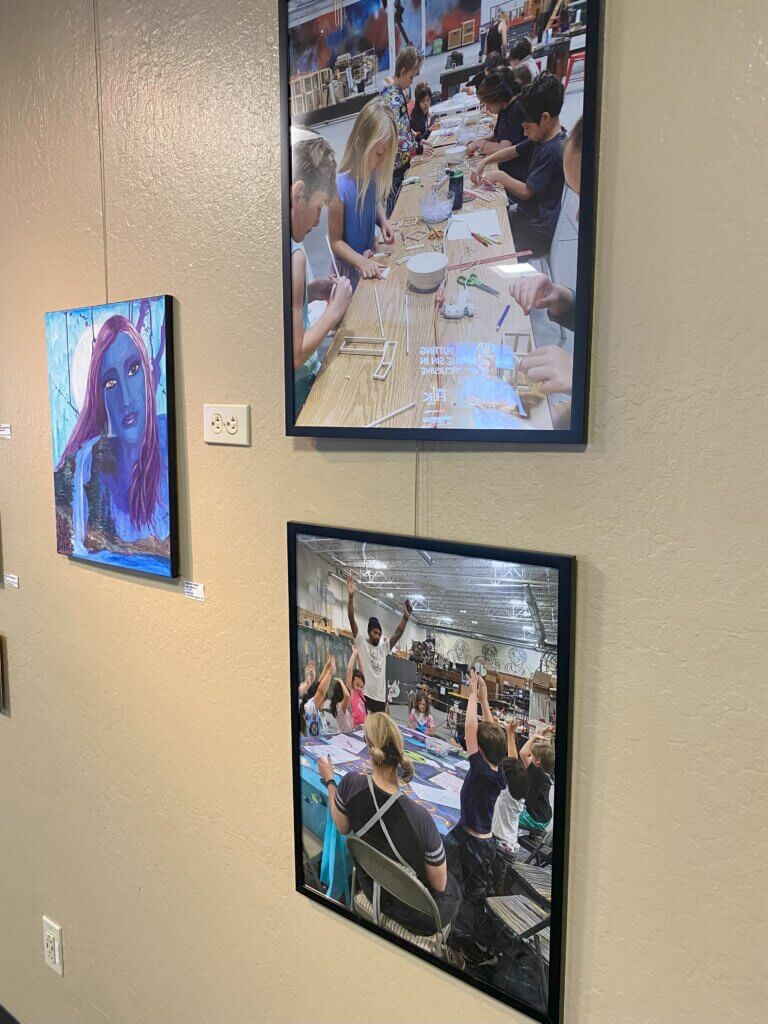 Framed photographs of art classes at The Generator. Piece with blue colored figure and waterfall.